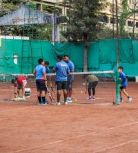 Tennis Coach Giving Instruction to Beginners